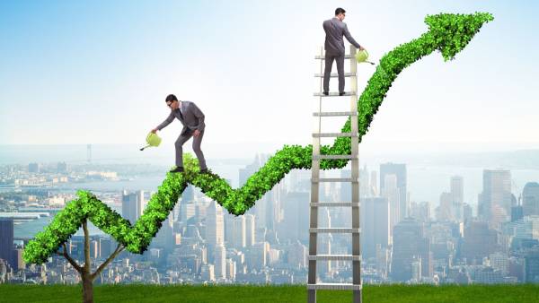 Wind farm among solar panels and sunrise in background