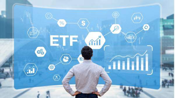 Mężczyzna stojący przed ekranem z napisem ETF, ikonami i wykresami