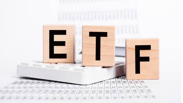 Fonds négociés en bourse. Cubes en bois avec texte ETF et papiers avec statistiques montrant la chute des marchés boursiers. Récession et crise économique. Concept d'investissement et de commerce.