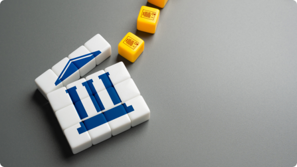 Biele kocky so symbolom modrej starogréckej budovy odkazujúce na bankovú inštitúciu a 3 žlté kocky odkazujúce na prvky bankového systému.