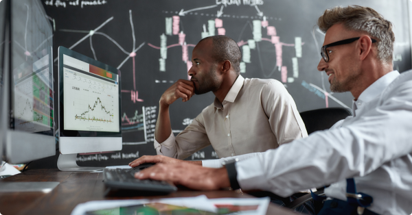Dos hombres frente a un ordenador en un artículo sobre qué son los bonos