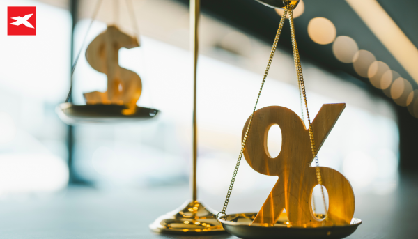 Bilancia con percentuale e dollaro sui piatti